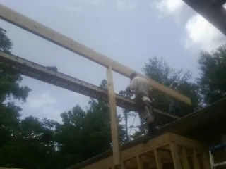 Carpenter setting a ridge beam over a new addition frame — Ice Dam Removal by Roofing Brothers in Tucker