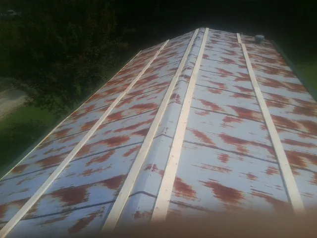 Rusted metal roof panels with new wood purlins before replacement — Storm Damage Roof Repair in Tucker by Roofing Brothers