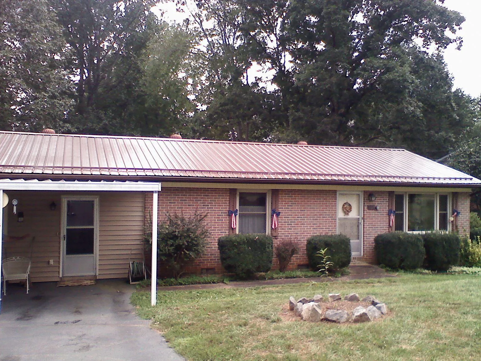 Bronze metal roof and carport on a brick ranch home — Roof Repair work by our crew in Tucker
