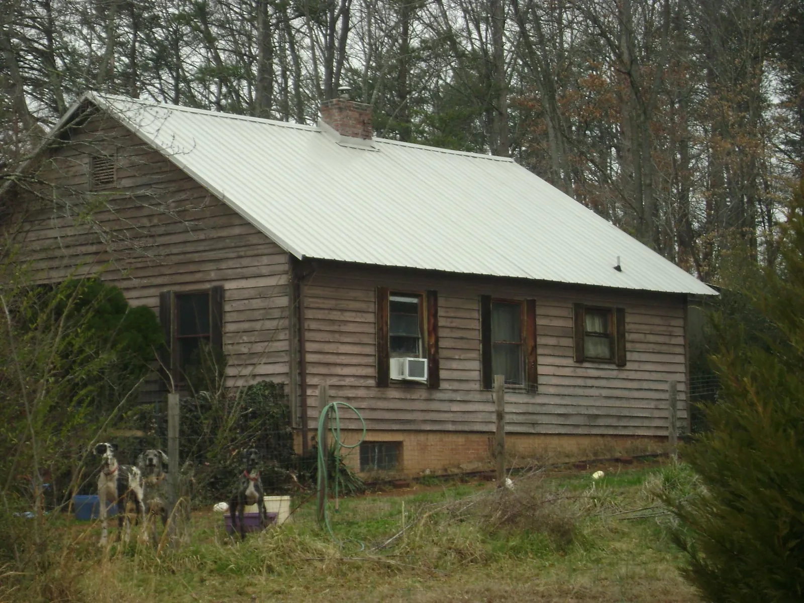 White metal roof on an old wood sided farmhouse, from a Metal Roof Installation job in Tucker